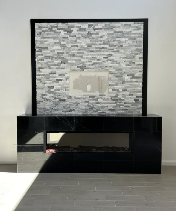 Stacked stone fireplace with black marble