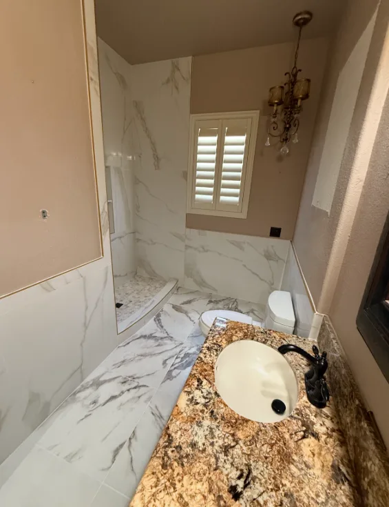 Powder bath with marble-look tile & mosaic pan