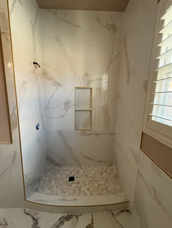 Curved marble-look shower with niche
